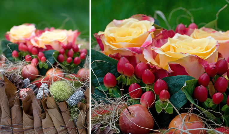 Schikking van rozen en Hypericum met sierappels